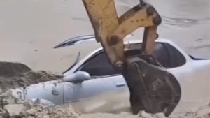 Veículo submerso em praia é retirado com ajuda de escavadeira